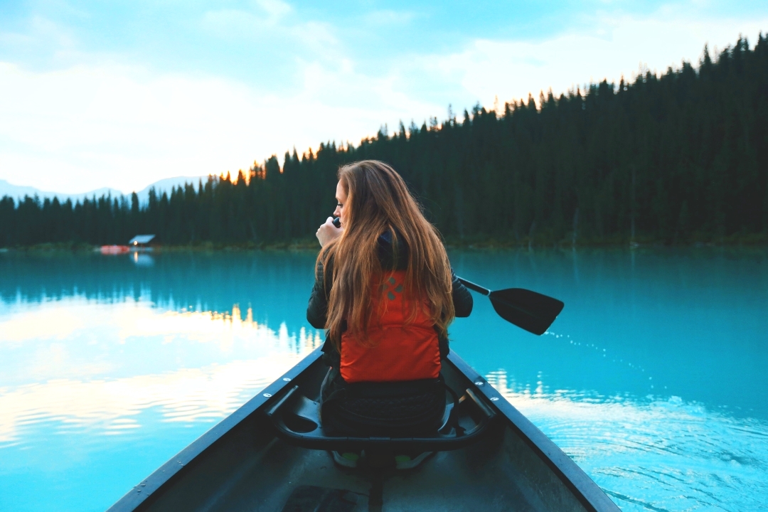 woman in kayak on blue lake