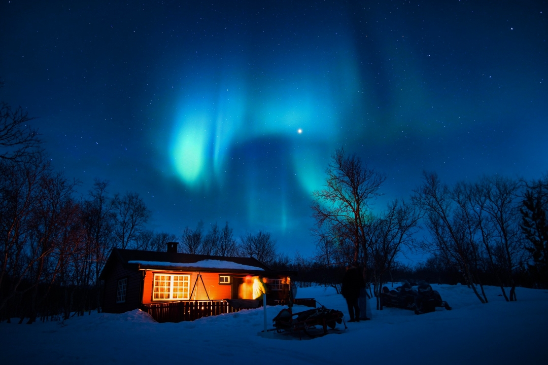 cabin in the snow with northern lights