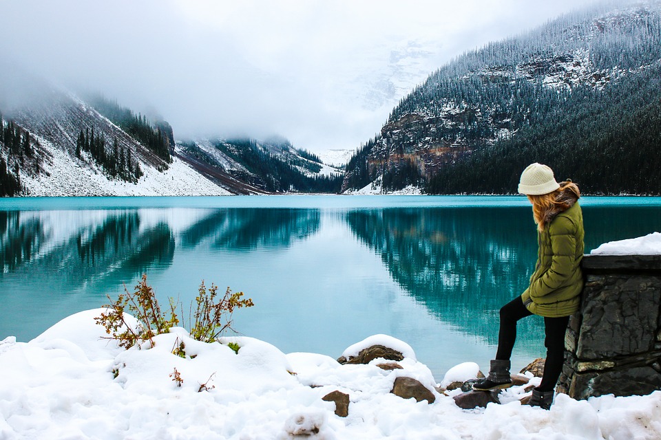 woman standing near lake in snow
